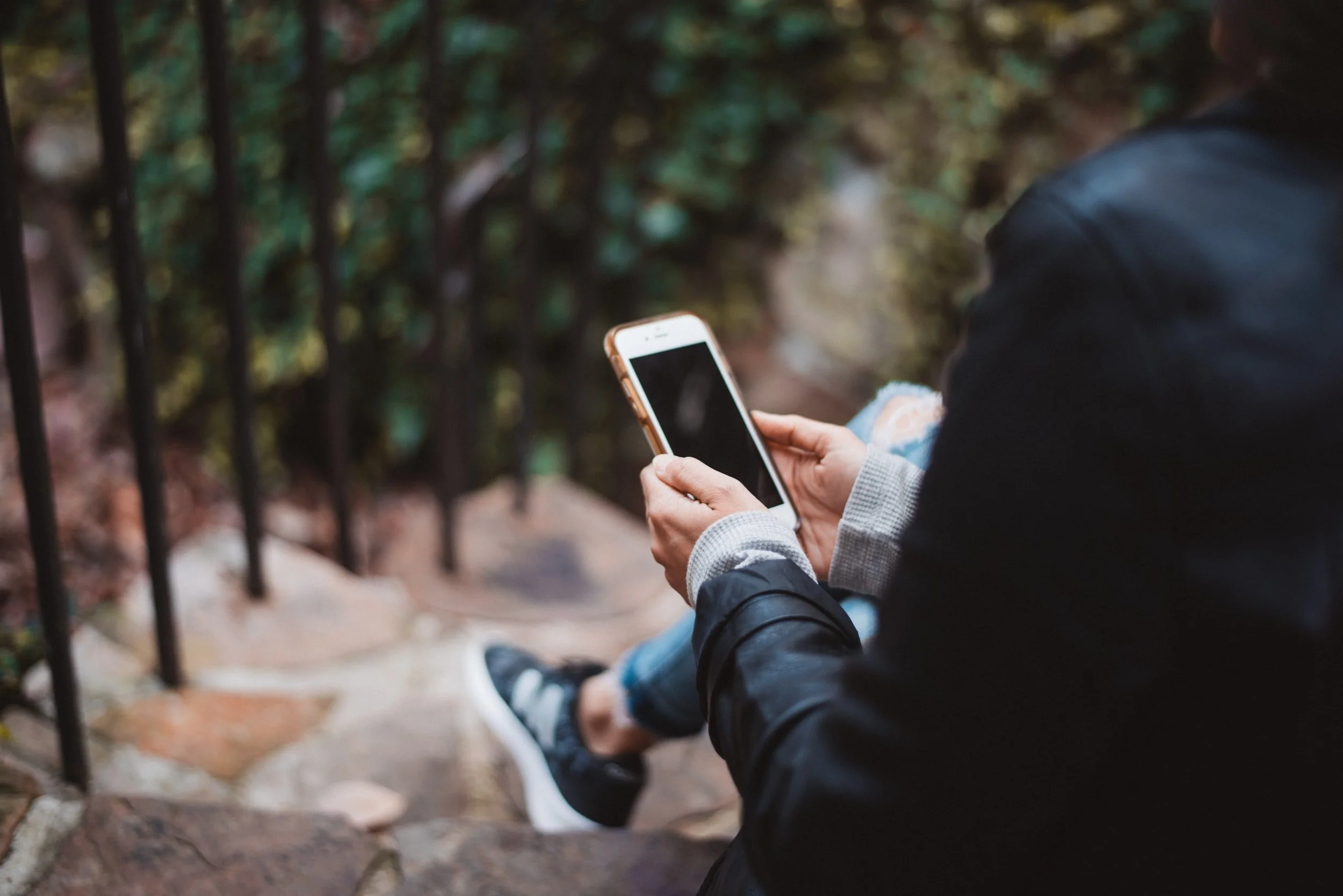 Reader engaged with content on their phone outdoors